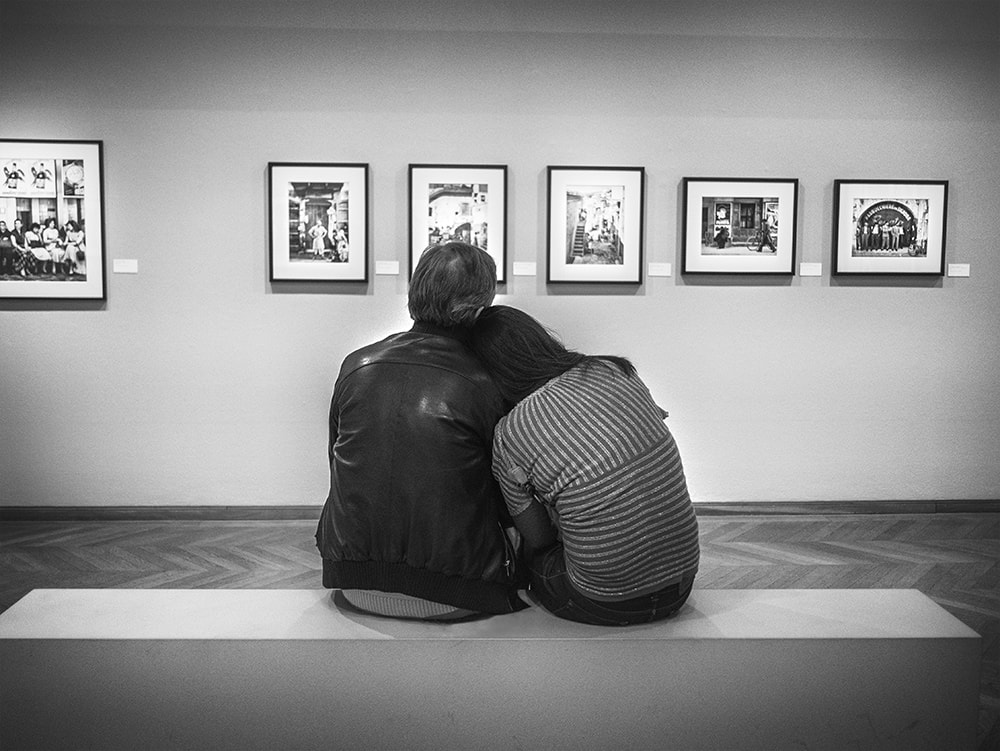 back of couple looking at art. black and white.