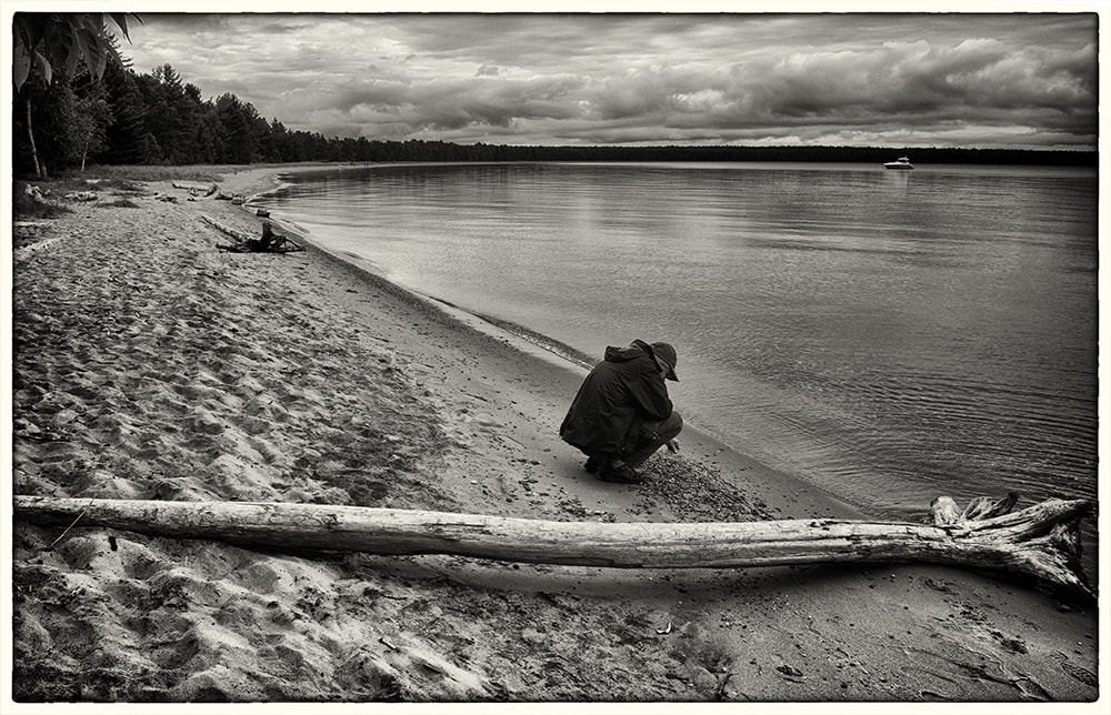solitary man at edge of lake, black and white