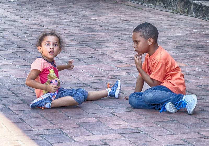 two children boy and girl play sitting on ground.