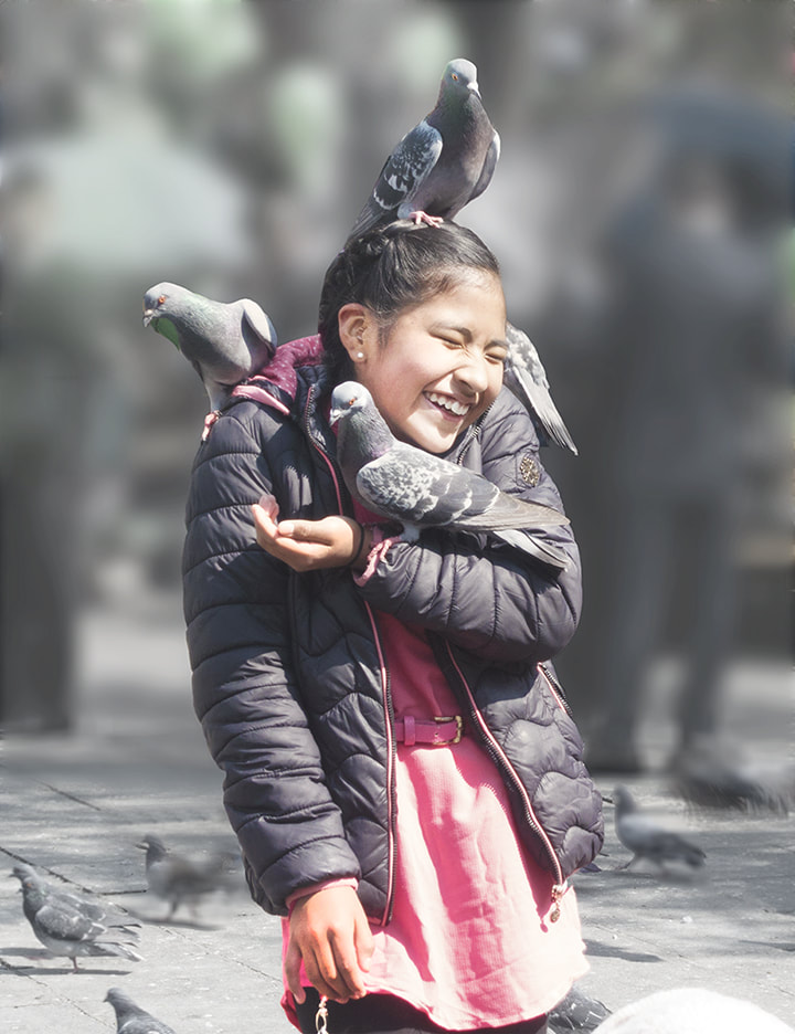 Smiling girl with pigeons in LaPaz, Bolivia.