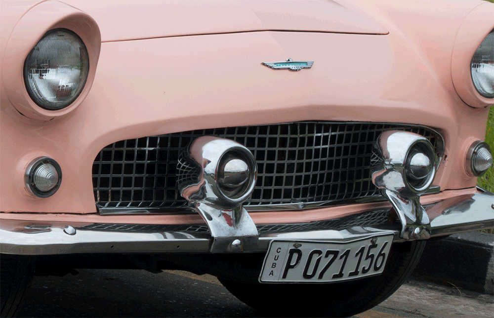 front of pink thunderbird in cuba