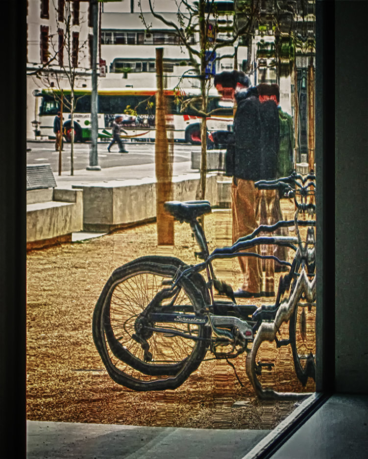 Man with bicycle seen through thick distored window. urban.